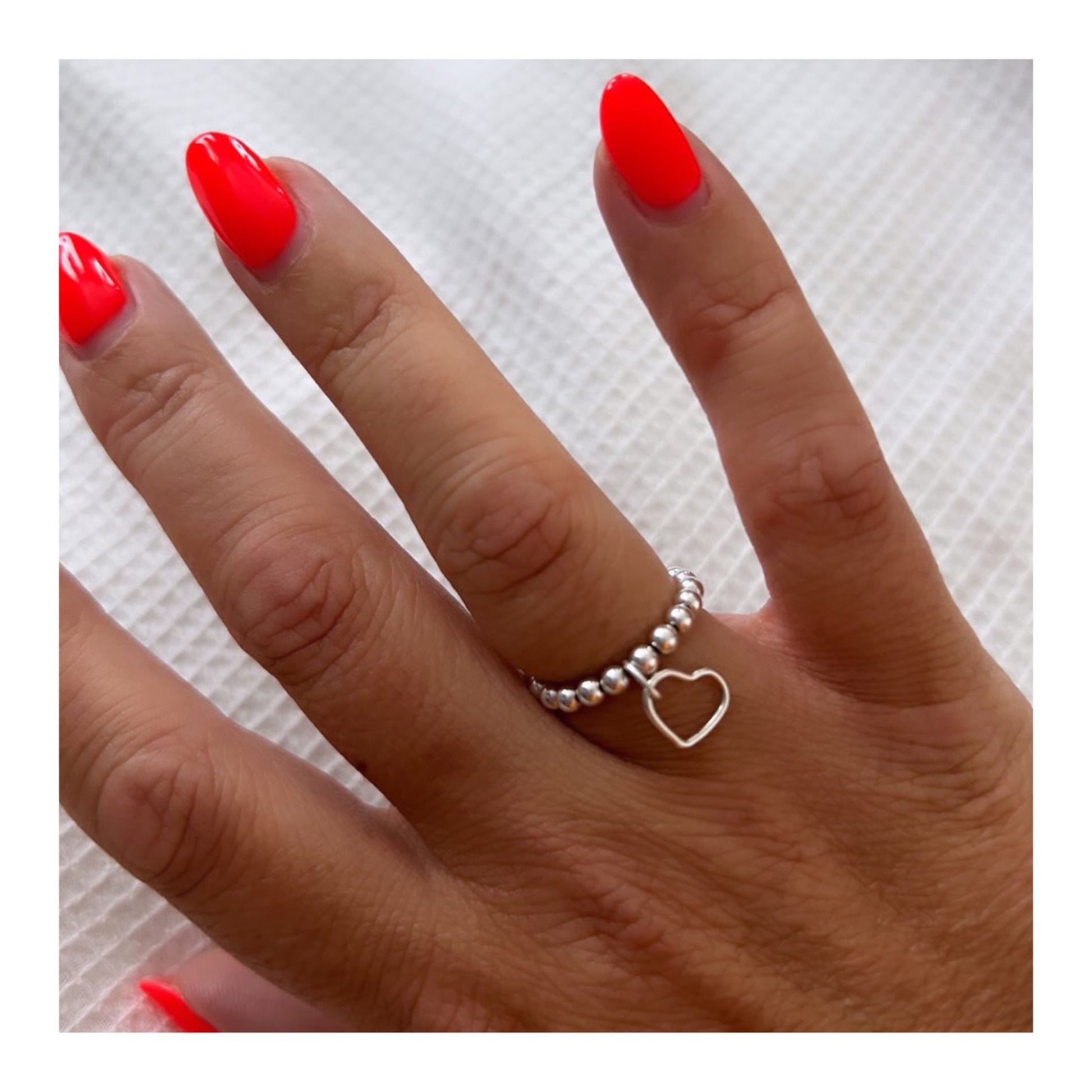 Woman wearing silver handmade stacking ring with heart